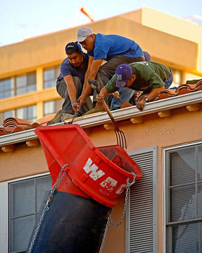 Latino construction crew close to a roof edge