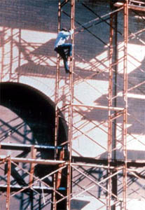 Man using scaffolding crossbraces as access 