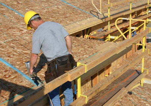 Figure 8 – A worker sheathing a roof from a bracket scaffold.