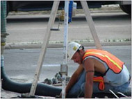 Photo of worker entering man hole