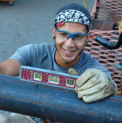 Construction worker using a level and wearing safety goggles