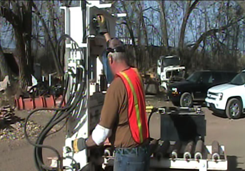 Worker using a stone cutter while wearing protective gear.