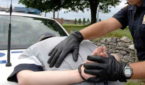 photo of police officer with suspect on the hood of a car