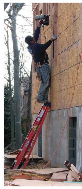 image of worker on ladder with nailgun