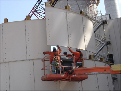 Men on a lift putting a panel into place. Photo courtesy of International Brotherhood of Boilermakers.
