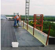 workmen installing a parapet wall on a bridge