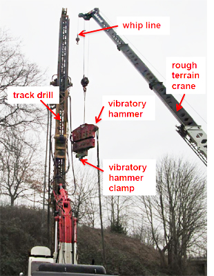 Picture of the equipment crane with the hydraulic vibratory hammer clamp attached
