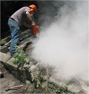 Man working with a chainsaw and silica dust