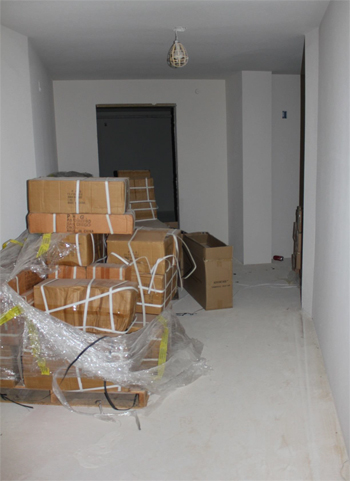 This is a photo of a hallway with a pallet piled with boxes and other boxes