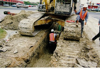 dangerous behavior when a person is in a trench with heavy machinery above them.