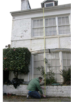 Man measuring the height from the roof to the ground